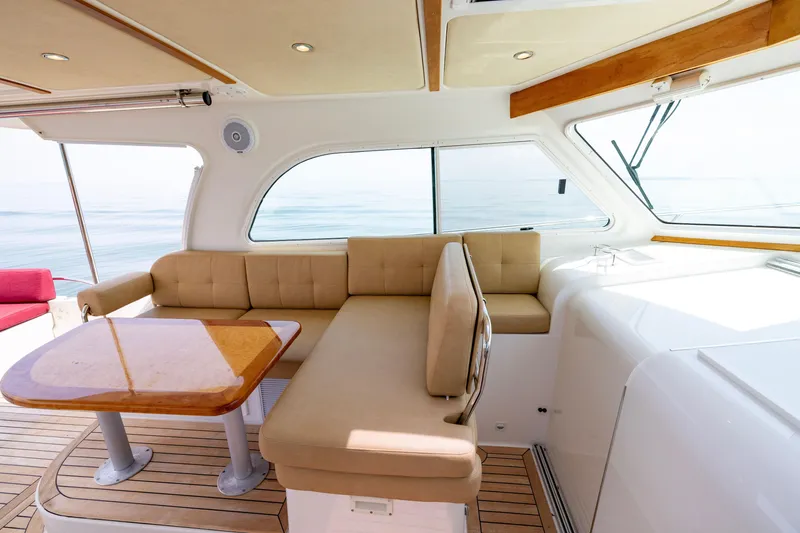 Slide: The Image of Luxurious interior of 2018 Back Cove Downeast 37 yacht with beige seating and wooden table. - 26