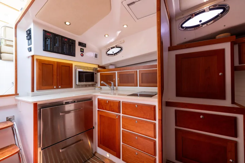 Slide: The Image of 2018 Back Cove Downeast 37 yacht kitchen with wood cabinets and modern appliances. - 34