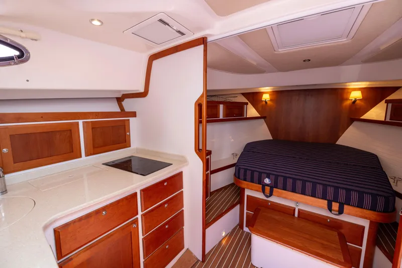 Slide: The Image of 2018 Back Cove Downeast 37 interior with kitchenette and cozy sleeping area. - 37