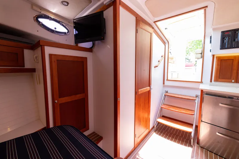 Slide: The Image of 2018 Back Cove Downeast 37 interior with wooden cabinetry, stairs, and modern amenities. - 40