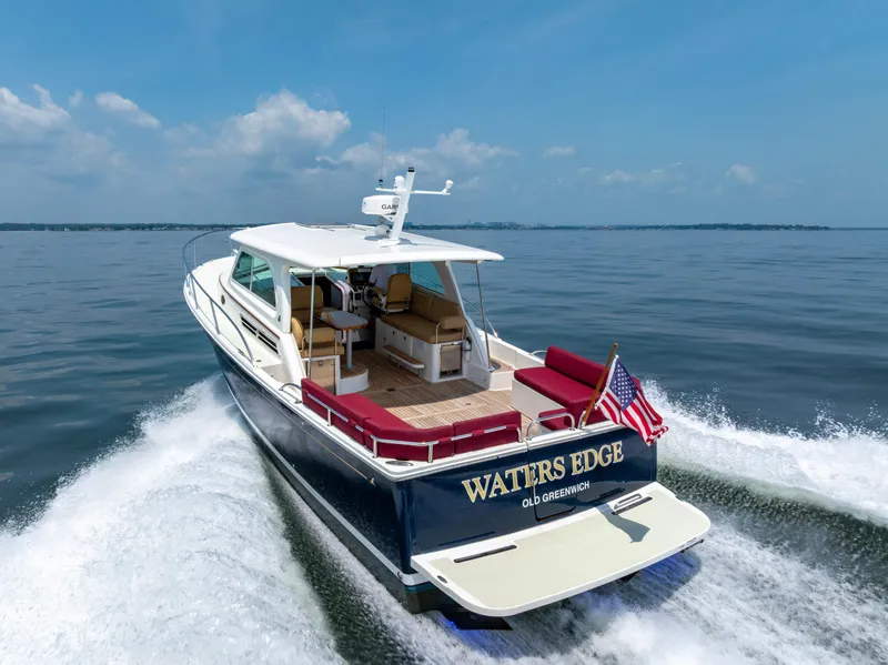 Slide: The Image of 2018 Back Cove Downeast 37 cruising on open water, rear view with American flag. - 5