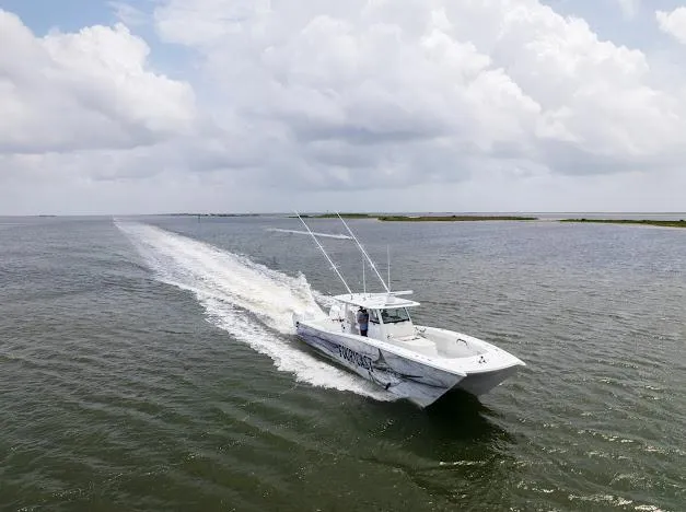 Slide: The Image of 2022 Freeman 47 boat docked by a wooden pier under a clear blue sky. - 14