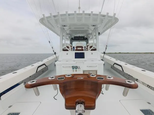 Slide: The Image of 2022 Freeman 47 boat cruising on a calm lake under a blue sky. - 24