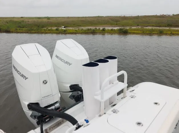 Slide: The Image of Four Mercury outboard engines on a 2022 Freeman 47 boat docked by a serene waterway. - 32