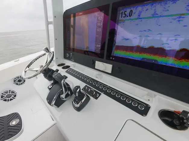Slide: The Image of Twin Mercury outboard engines on a 2022 Freeman 47 boat, near a calm waterway. - 35