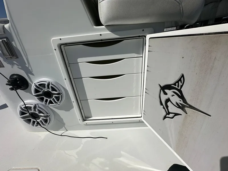 Slide: The Image of Open storage compartment on a 2022 Freeman 47 boat with multiple rod holders. - 63