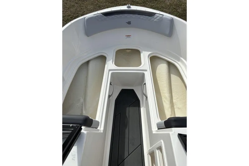 Slide: The Image of 2025 Bayliner Element M17 boat interior with seating and windshield, parked outdoors. - 16
