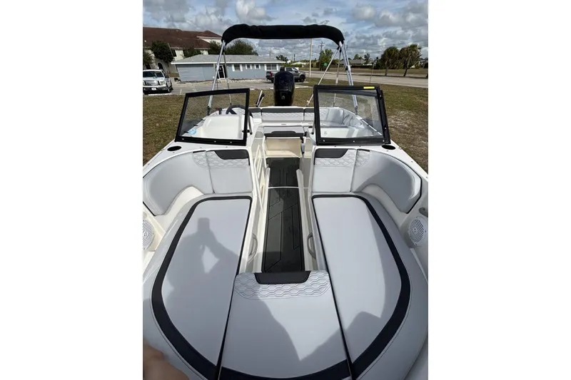 Slide: The Image of 2025 Bayliner Element M17 boat interior with seating and open windshield under a cloudy sky. - 17