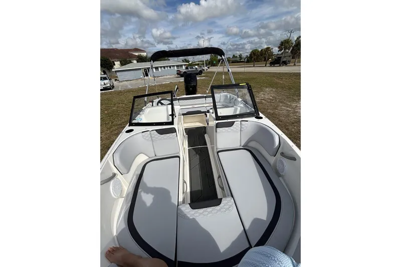 Slide: The Image of 2025 Bayliner Element M17 boat interior with seating and windshield, parked outdoors. - 18