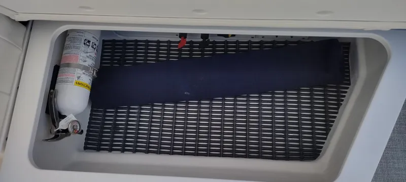Slide: The Image of Storage compartment in a 2024 Formula 290 BR boat with fire extinguisher. - 28