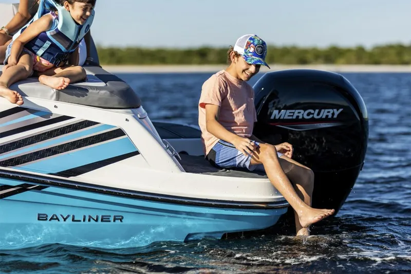Slide: The Image of 2025 Bayliner VR5 Bowrider OB boat on trailer, featuring a Mercury outboard motor. - 2