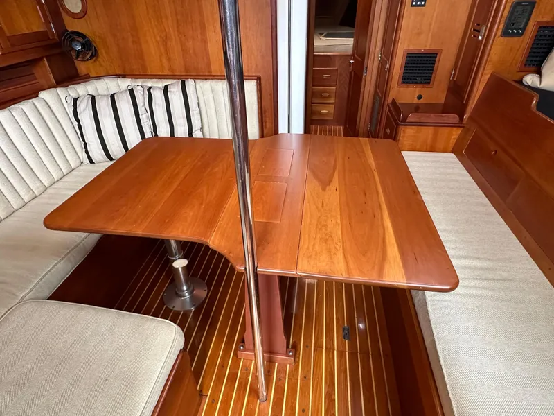 Slide: The Image of Interior of 1987 Hinckley Sou'wester 42 sailboat with wooden table and cushioned seating. - 11