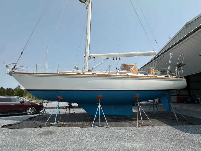 Slide: The Image of 1987 Hinckley Sou'wester 42 sailboat on stands, displayed outdoors near a building. - 13