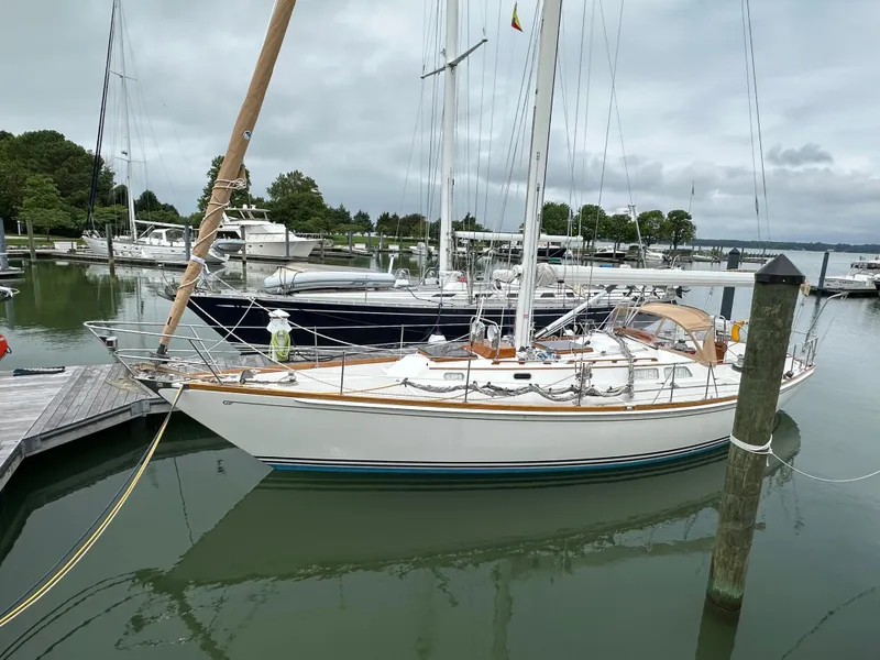 Slide: The Image of 1987 Hinckley Sou'wester 42 sailboat docked in a marina, surrounded by calm waters. - 16