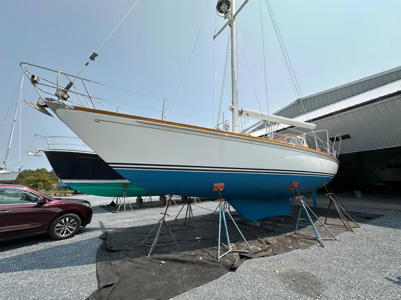 Slide: The Image of 1987 Hinckley Sou'wester 42 sailboat on stands, displayed outdoors near a building. - 37