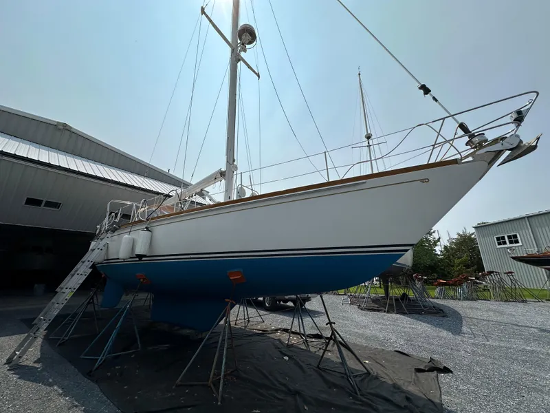 Slide: The Image of 1987 Hinckley Sou'wester 42 sailboat on stands, outside a storage building. - 38