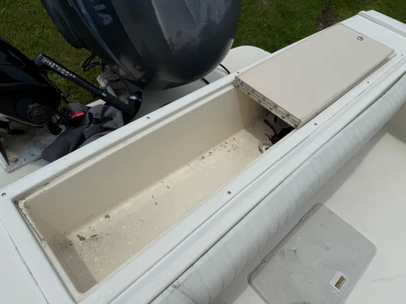 Slide: The Image of 2002 Parker 2510 Walkaround boat storage compartment with open lid, showing interior space. - 10