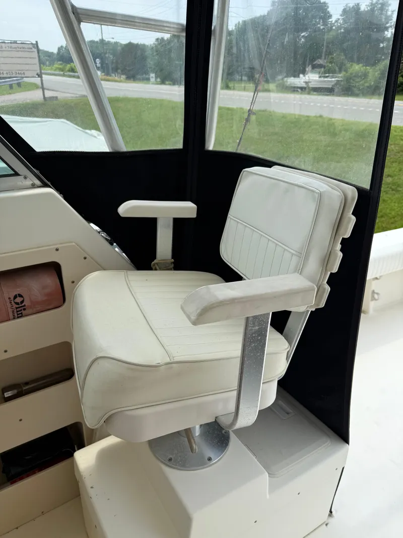 Slide: The Image of Captain's chair on 2002 Parker 2510 Walkaround boat, featuring white upholstery and armrests. - 12