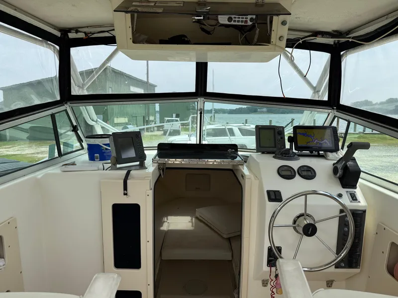 Slide: The Image of 2002 Parker 2510 Walkaround boat cockpit with steering wheel and navigation equipment. - 7