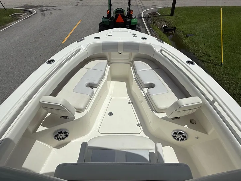 Slide: The Image of 2020 Mako 236 CC boat interior with cushioned seating and speakers. - 14