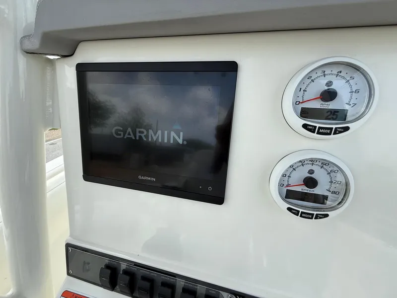 Slide: The Image of 2020 Mako 236 CC dashboard with Garmin display and gauges. - 18