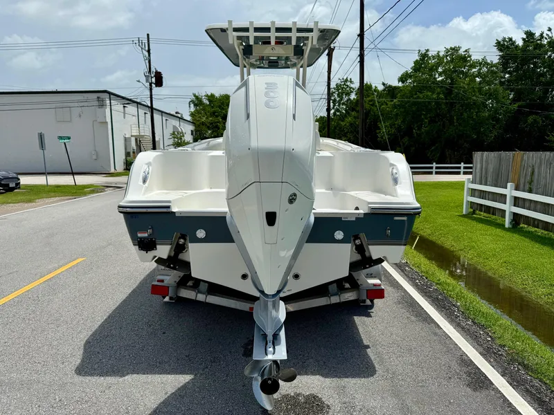 Slide: The Image of 2020 Mako 236 CC boat on trailer, parked on a suburban street. - 3