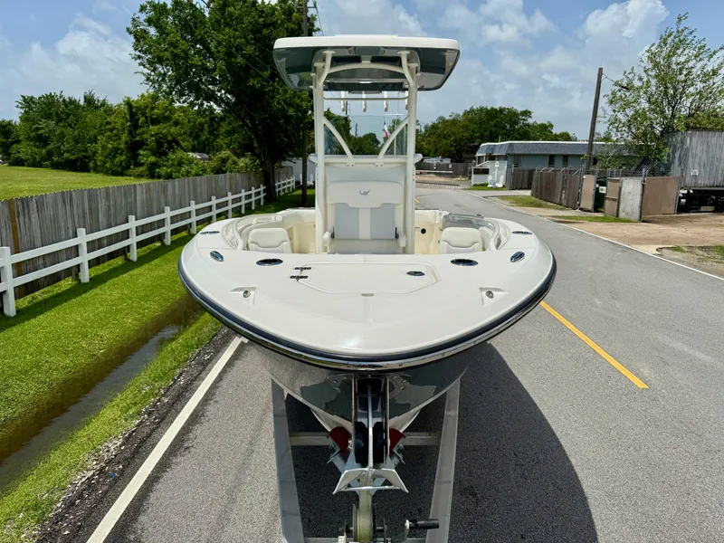 Slide: The Image of 2020 Mako 236 CC boat on trailer, parked on a suburban street. - 6