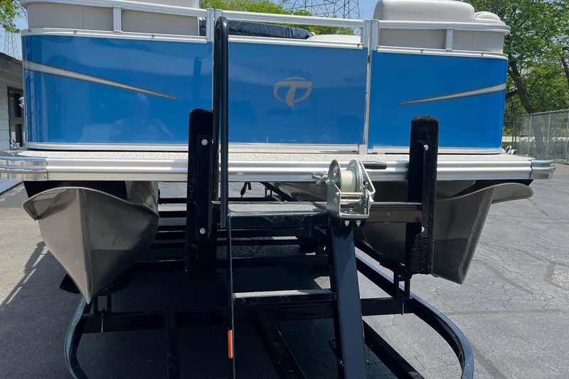 Slide: The Image of 2022 Tahoe 182 S pontoon boat on trailer, blue exterior, parked outdoors. - 17