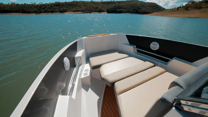 Slide: The Image of 2025 Ventura V195 Crossover boat interior with cushioned seating on a serene lake. - 3
