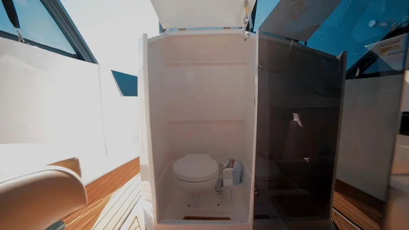 Slide: The Image of 2025 Ventura V195 Crossover boat interior with compact bathroom and wooden flooring. - 6