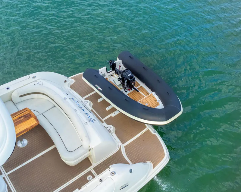 Slide: The Image of 2025 Geniuss 330 Cruiser with inflatable boat on water, featuring spacious deck seating. - 18