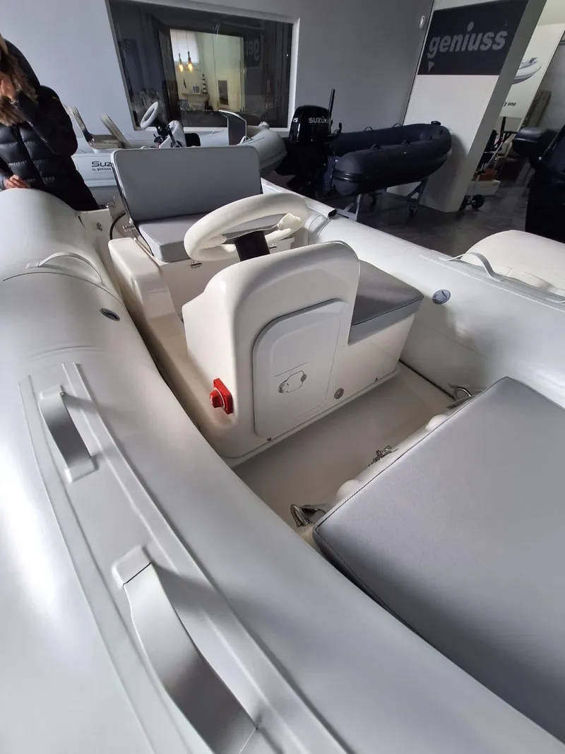 Slide: The Image of 2025 Geniuss 330 Cruiser boat interior with white seating and steering console. - 20