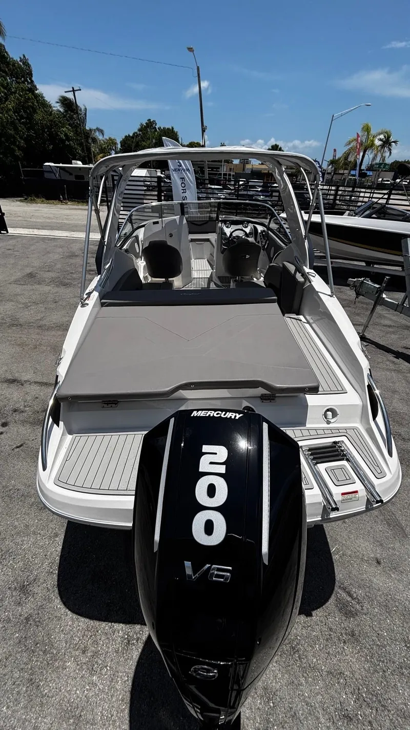 Slide: The Image of 2025 Ventura V250 Comfort boat with Mercury 200 V6 engine, docked under clear blue sky. - 4