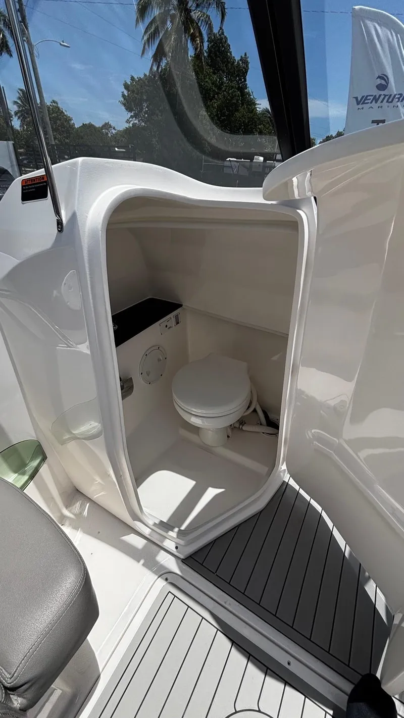 Slide: The Image of 2025 Ventura V250 Comfort boat interior with compact marine toilet. - 6