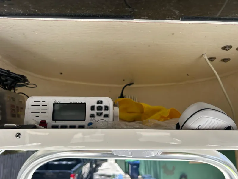 Slide: The Image of 2023 Key West 239 FS boat interior with radio equipment and storage compartment. - 19