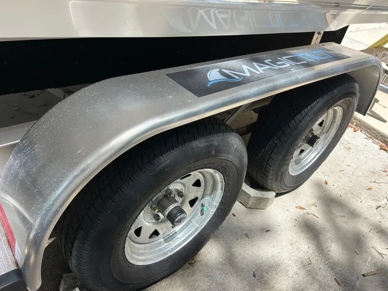 Slide: The Image of Trailer wheels of a 2023 Key West 239 FS boat on a concrete surface. - 22