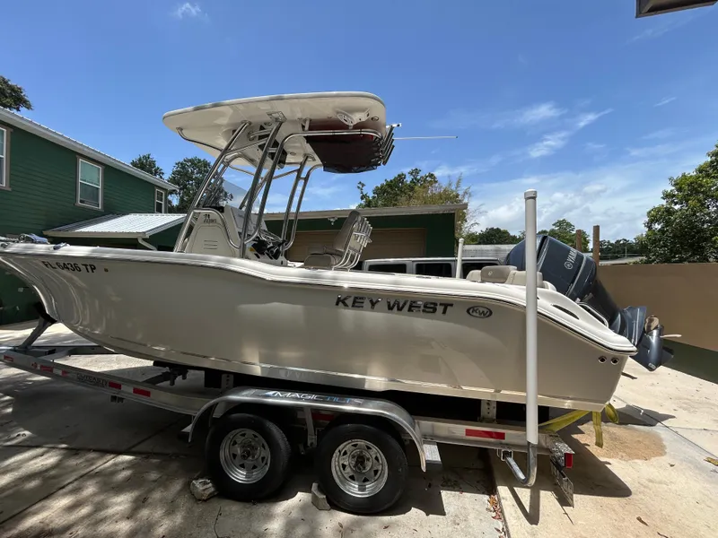 Slide: The Image of 2023 Key West 239 FS boat on trailer, parked outdoors under clear sky. - 3