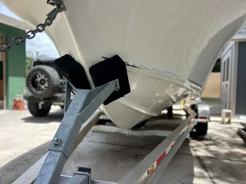 Slide: The Image of 2023 Key West 239 FS boat on trailer, close-up view of hull and support. - 4