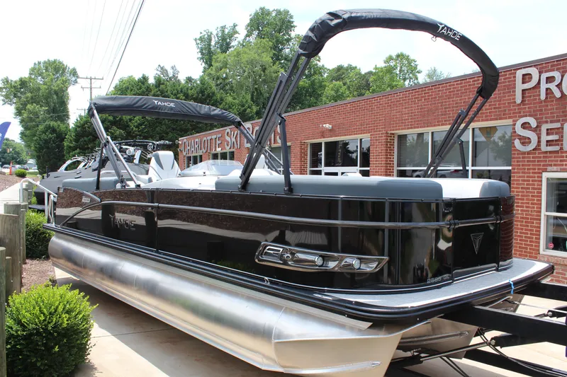 The Image of 2025 Tahoe Pontoon Cascade Quad Lounger, black exterior, parked near a brick building. - 0