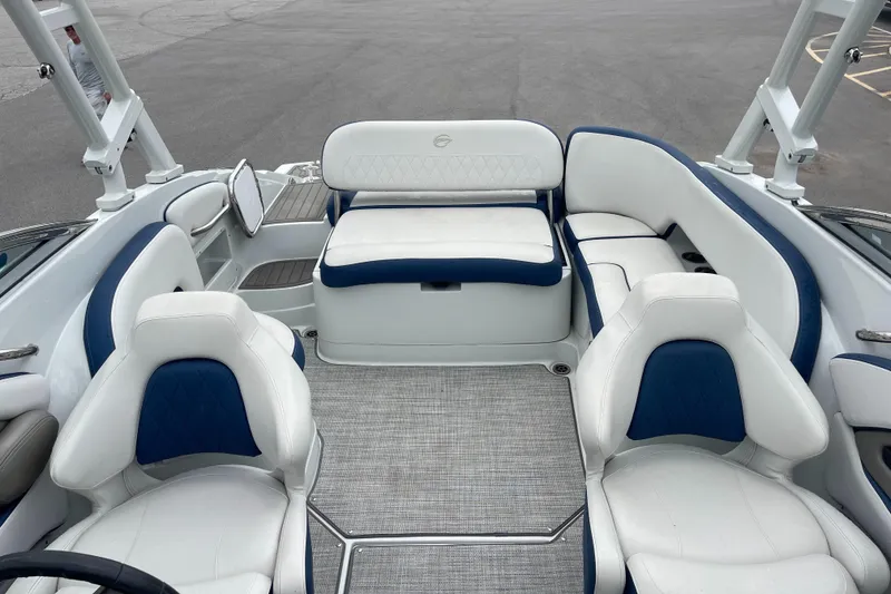 Slide: The Image of 2023 Crownline E235 boat interior with white and blue seating, spacious layout. - 7
