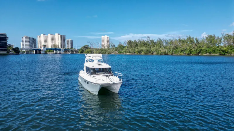 Slide: The Image of 2023 ArrowCat Flybridge Dual Helm boat on a serene blue waterway. - 18