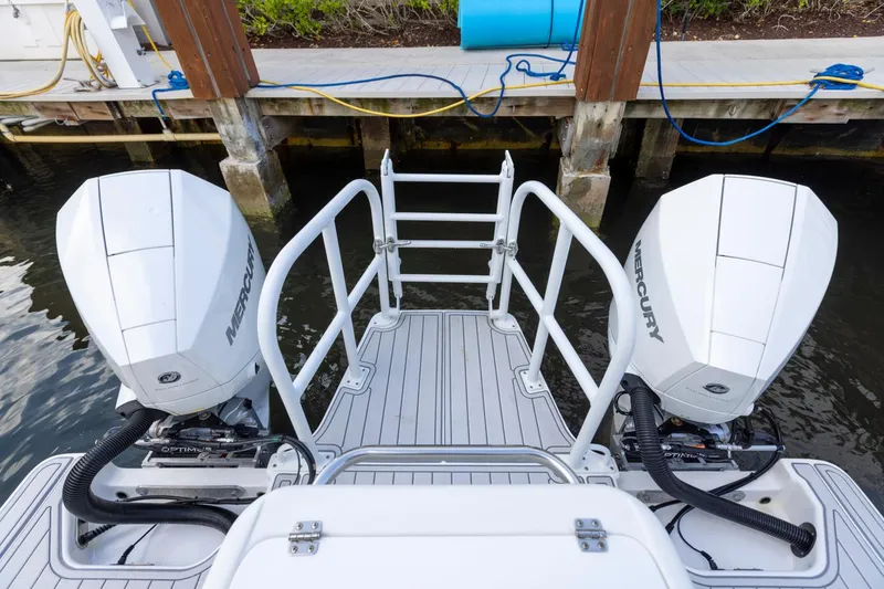 Slide: The Image of 2023 ArrowCat Flybridge Dual Helm with twin Mercury outboard engines at dock. - 27