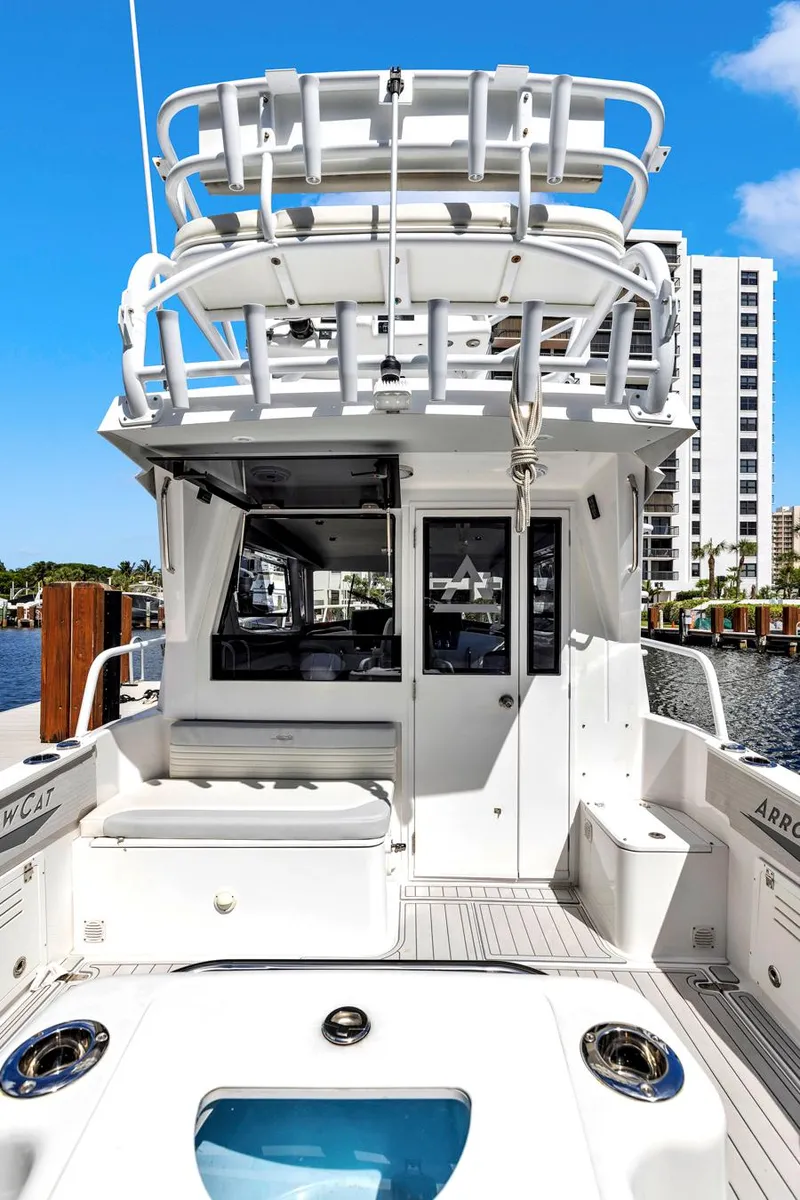 Slide: The Image of 2023 ArrowCat Flybridge Dual Helm boat docked, showcasing rear view and upper deck. - 30