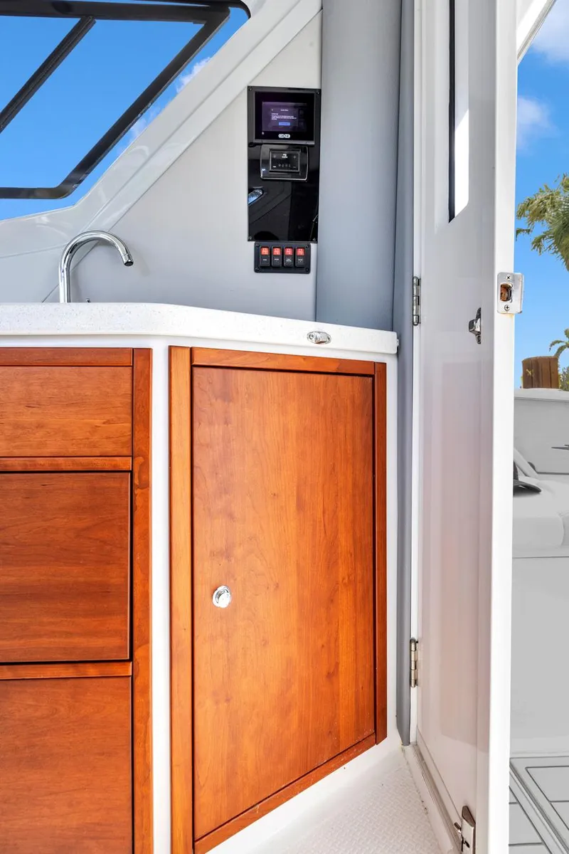 Slide: The Image of 2023 ArrowCat Flybridge Dual Helm interior with wooden cabinetry and modern controls. - 44