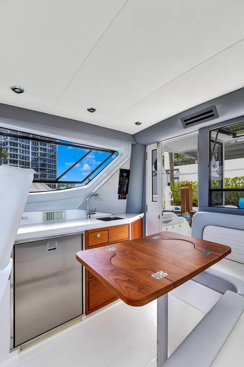 Slide: The Image of 2023 ArrowCat Flybridge Dual Helm interior with kitchenette and wooden table, featuring modern design. - 47