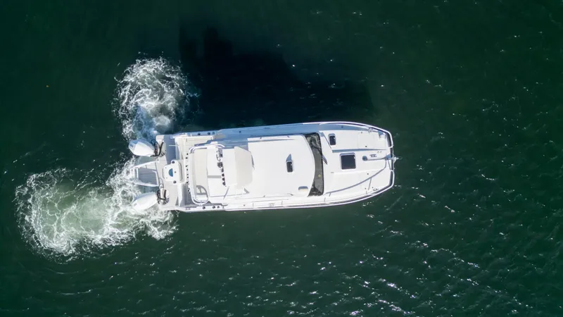 Slide: The Image of Aerial view of 2023 ArrowCat Flybridge Dual Helm boat cruising on water. - 5