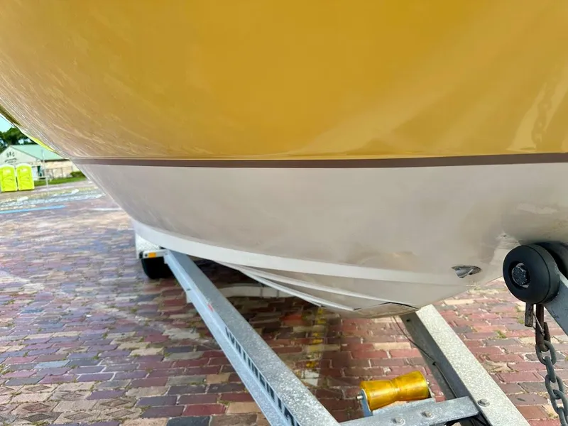 Slide: The Image of 2004 Sea Ray SUNDECK 270 boat on trailer, showing hull and brick pavement. - 10