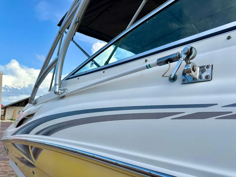 Slide: The Image of 2004 Sea Ray SUNDECK 270 boat, close-up view, sleek design, blue sky background. - 12