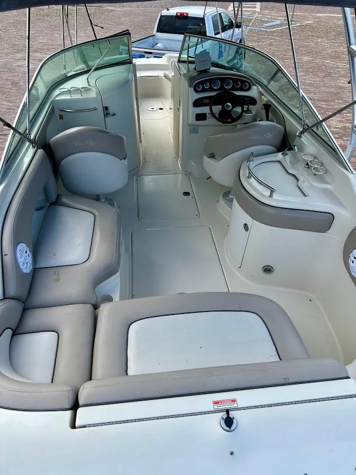 Slide: The Image of 2004 Sea Ray SUNDECK 270 interior with seating and helm, showcasing spacious design. - 18