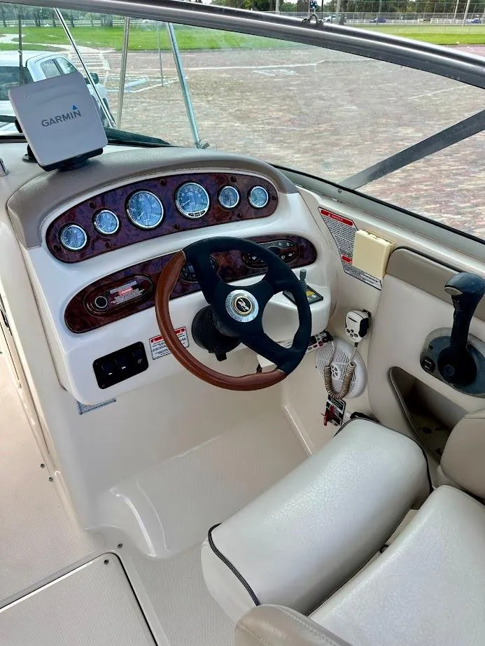 Slide: The Image of 2004 Sea Ray SUNDECK 270 helm with Garmin GPS, wood-accented steering, and modern controls. - 28